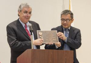 Inerim Board Chair Justin Tsui and CEO Paul Little with the plaque that is presented to the Tournament of Roses. Plaque for the Tournament of Roses